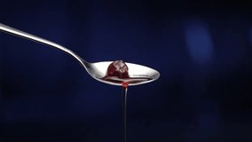 static macro shot of cherry with syrup being dropped out of shiny spoon - Powered by Shutterstock - Get 15% off with code: PIKWIZARD15
