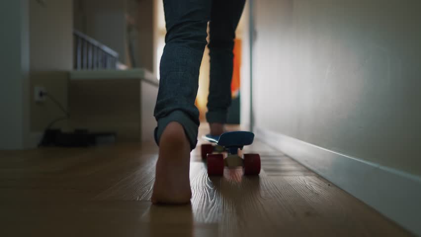 child riding skateboard at home. daughter girl legs close-up plays skateboard corridor indoors. happy family kid dream concept. child learning to ride a skateboard at home funny lifestyle Royalty-Free Stock Footage #1102464737