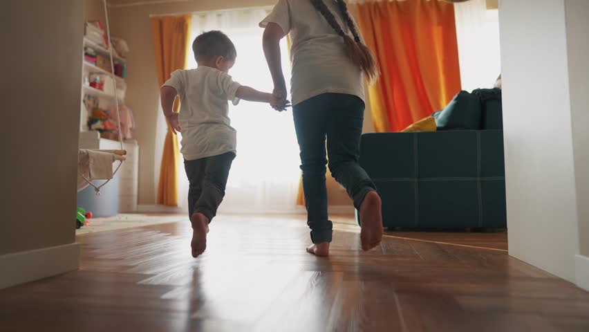 Children running around house playing silhouette. happy family kid dream concept. kids feet running back view indoors light from dream window. children run and play. brother sister lifestyle run