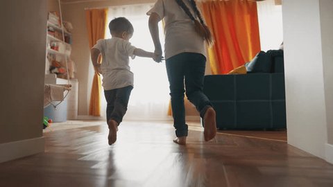 children running around house playing silhouette. happy family kid dream concept. kids feet running back view indoors light from dream window. children run and play. brother sister lifestyle run Video de stock