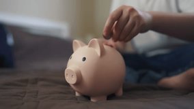 child hands hoarding coins put in piggy bank. happy family accumulation business concept. child saving coins in a piggy bank close-up. child hands puts dream coins in a large piggy bank indoors - Powered by Shutterstock - Get 15% off with code: PIKWIZARD15