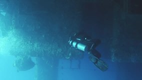 Vertical video, Scuba diver swim along deck of ferry Salem Express shipwreck approaching the ship's superstructure, Slow motion