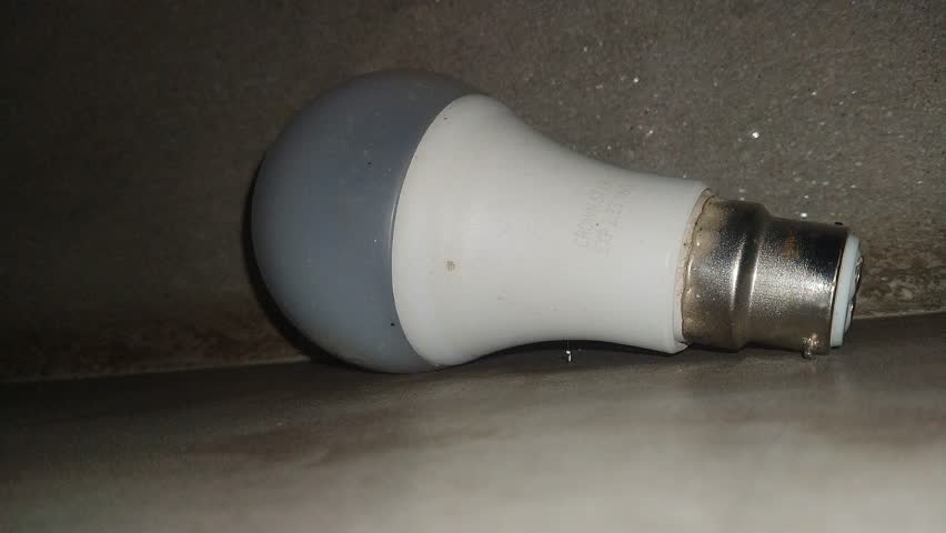 4k footage of White light buld. Light buld isolated against low light background.