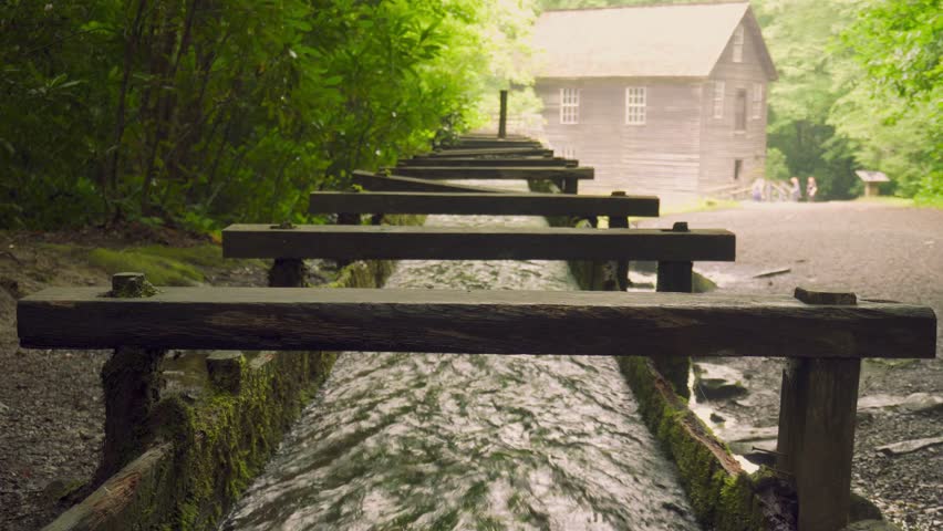 Mingus Mill at Great Smoky Mountains National Park. Water flows down a millrace to the mill. Historic gristmill was used for corn meal milling. 