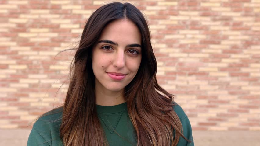 Close up outdoor portrait of cheerful young attractive brunette woman smiling at camera. Positive emotion, happiness and people concept.