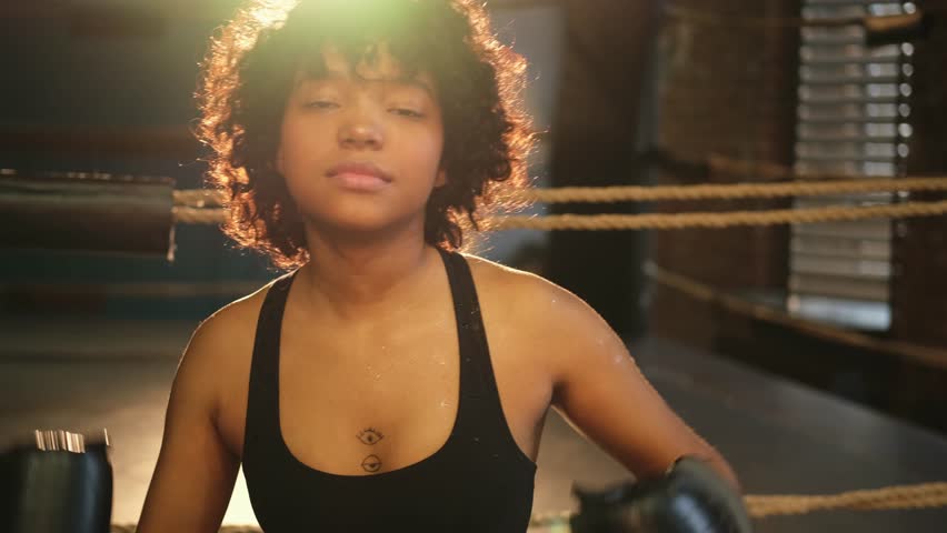 Outcry independent girl power. Angry african american woman fighter with boxing gloves looking serious aggressive to camera standing on boxing ring. Strong powerful girl looking concentrated straight Royalty-Free Stock Footage #1102475653