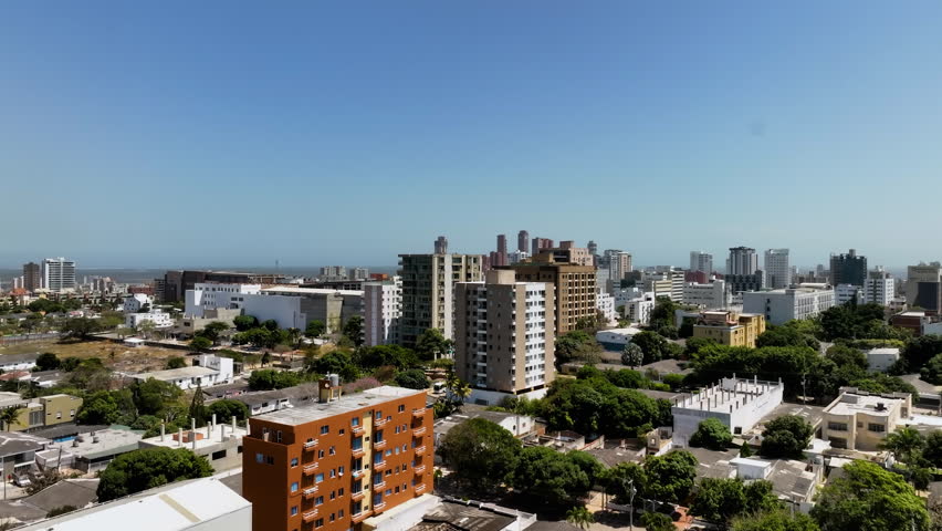 Ascending aerial view of the cityscape of Barranquilla city, in sunny Colombia