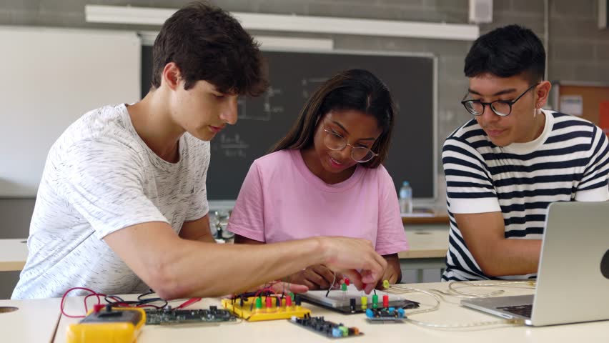 Group of diverse teenage high school students learning together to build electronic circuits at classroom. Millennial ethnic classmates working at technology class Royalty-Free Stock Footage #1102480915