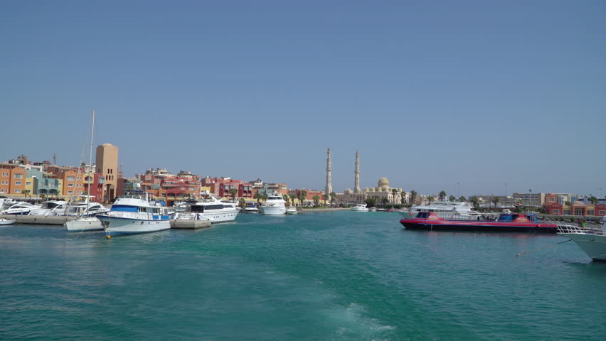 Yacht sailing away from the Hurghada Marina with view of the Hurghada traditional colorful buildings and El Mina mosque