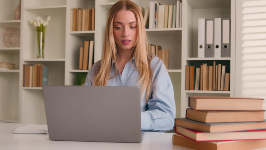 Caucasian happy female student girl at home library studying online with books laptop distant education writing homework task e-learning. Woman businesswoman corporate study with computer write ideas Royalty-Free Stock Footage #1102481387