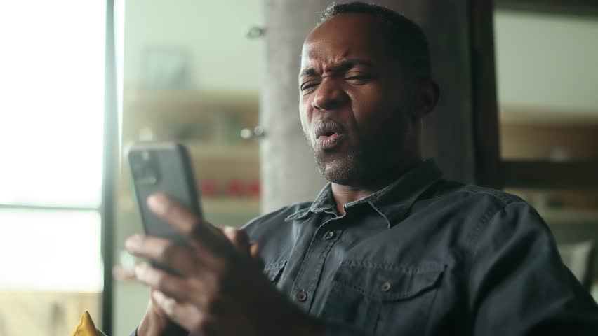 Portrait of handsome mature african american man browse products in internet online shopping store planning trip travel or swiping through profiles on dating app on smartphone at home Choice concept