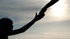 Helping hand. Silhouette of an adult's hand reaching out to a child. - Powered by Shutterstock - Get 15% off with code: PIKWIZARD15