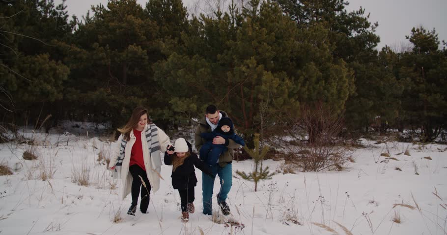 Happy European family walking have fun among snow nature in winter. Father mother with children playing together Christmas. Slowmo tracking shot of happy man pulling sled laughing running forest 4k | Shutterstock HD Video #1102489183