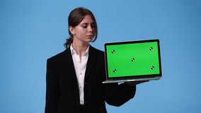 4k video of one girl using chroma key laptop and showing thumbs up over blue background.
