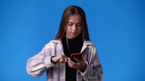 4k video of one girl showing something in his right hand over blue background.