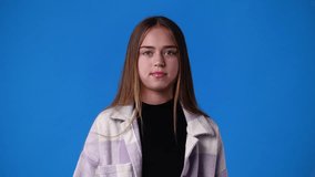 4k video of one girl showing thumb down on blue background.