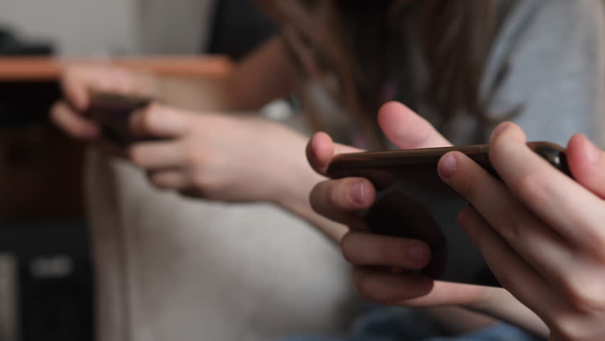 children spend leisure time using mobile devices, selective focus. children's hands playing mobile games on smartphones. children's addiction to gadgets