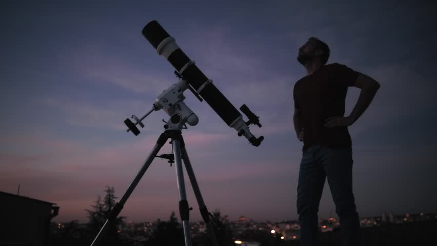 Astronomer looking at the starry skies with a telescope.	
