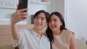 Young couple making selfie communicates with parents via video call. Phone conversation. Asian lover family talking video calling from new home. Happy distance friends chatting online in virtual app.