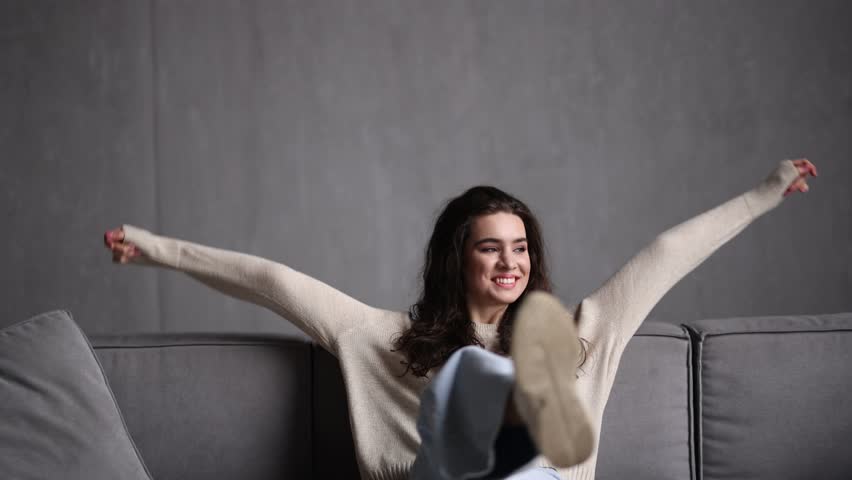 Young woman relaxing and dreaming on sofa at home