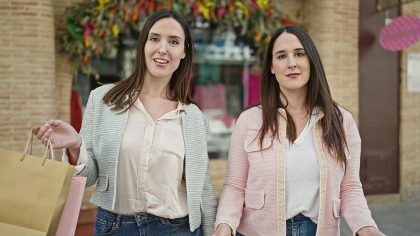 Two women customer holding shopping bags and credit card at street
