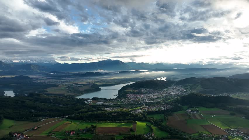 ALPS, AUSTRIA - OCTOBER, 2022: Aerial view of austrian mountain landscape with beautiful valley. Green meadows and autumn forest with yellow leaves around.