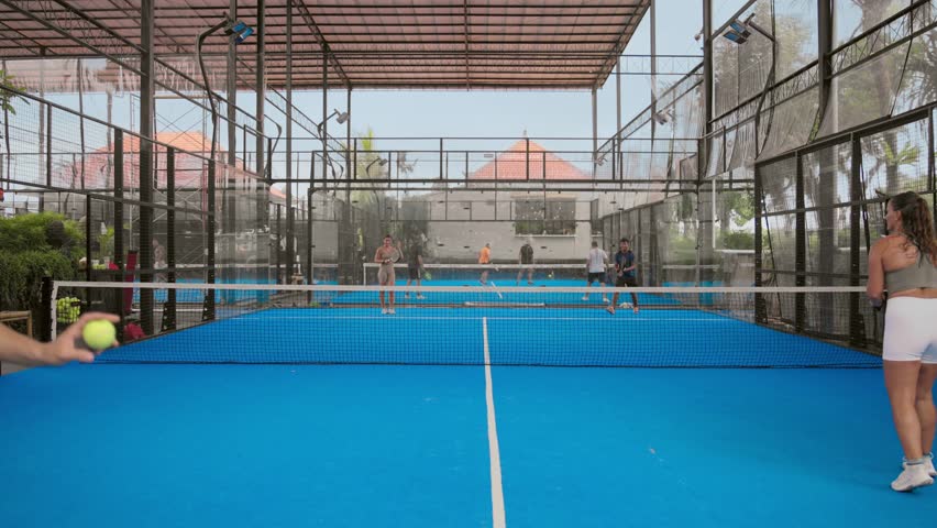 Man players serving ball. Young adult guy play tennis outside arena. Person racket beat game club. People group hit sport court match. Fit care free time. Run skill train. Padel tennis team workout. Royalty-Free Stock Footage #1102514125