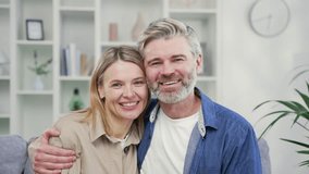 Webcam view. Close up of happy married couple hugging in living room at home looking at camera. Mature wife and husband cuddles, smile, rejoice looking at each other. Joyful moments of life together - Powered by Shutterstock - Get 15% off with code: PIKWIZARD15