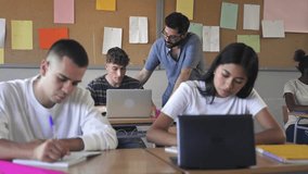 Young friendly teacher helping student learning with laptop at High School - Education in Europe - Powered by Shutterstock - Get 15% off with code: PIKWIZARD15