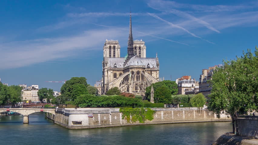 Seine and back side of Notre Dame de Paris timelapse hyperlapse is the one of the most famous symbols of Paris. View from Tournelle bridge with boats on river at sunny summer day