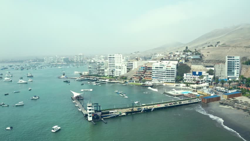 Aerial view of the bay, marina and buildings of Ancon - Lima, Peru; The beach and some exterior buildings in Ancon.