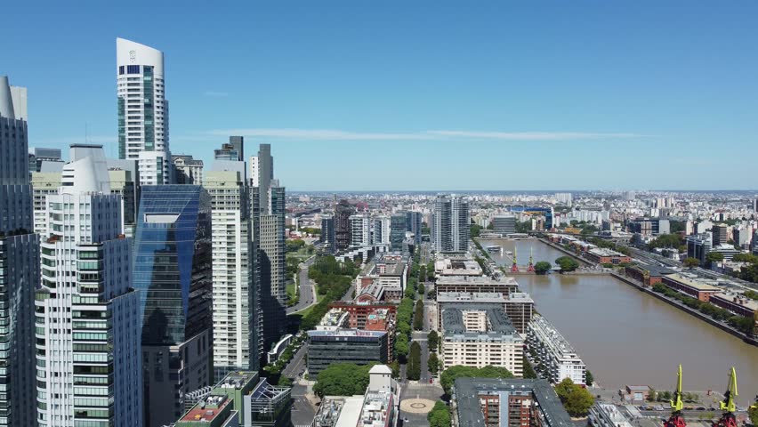 Buenos Aires, Argentina: Aerial drone footage of modern skyscrapers with luxury condo and office towers that are lined along the ancient Porto Madero in Buenos Aires on a sunny day 