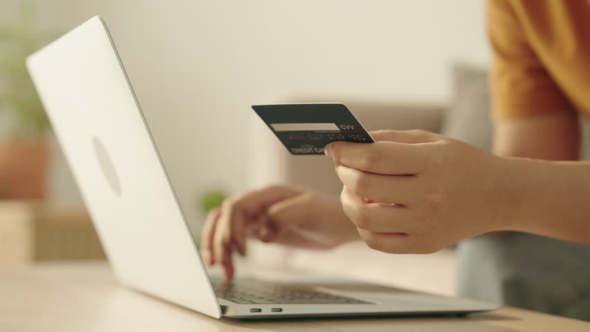 Side view. Hand of young women are buying online with a credit card. woman are using the laptop and doing online transactions at home. Concept of shopping online by technology and lifestyle new normal Royalty-Free Stock Footage #1102543823