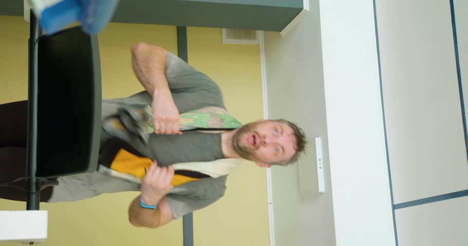 Heavy treadmill workout. Keeping fit in your 40s - middle-aged man with a towel on his neck runing on a treadmill. Slow motion vertical 4k footage.