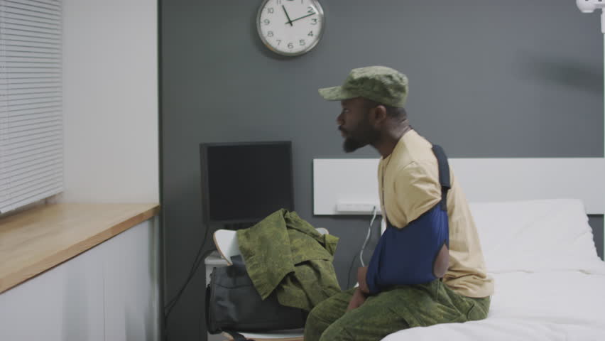 African American soldier waiting for doctor to get discharged from military hospital looking out of window