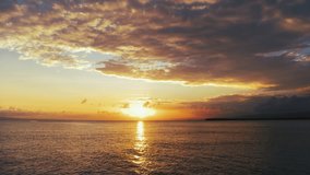 The sun touches the horizon. Sea sunset background, view from the beach. Sunset in blue sky with orange clouds over the Caribbean Sea. Nice summer seascape. Evening sun glare on the water.