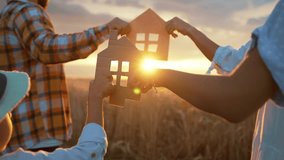 Family dream home, holding symbols of home, cardboard figures of house, love and happiness of parents and children, walking on picturesque golden field with wheat,bright sunshine in sunset. - Powered by Shutterstock - Get 15% off with code: PIKWIZARD15