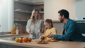 Happy Caucasian family preparing breakfast together talking at home kitchen mother hold glasses with milk little daughter child girl prepare toasts bread with chocolate pasta with father food delivery - Powered by Shutterstock - Get 15% off with code: PIKWIZARD15