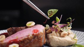 Final touch in dish serving. Cooking process. Luxury restaurant. Chef finishing duck dish with salad leaf. Serving plate with micro greens. final ingredients. restaurant kitchen. Full hd - Powered by Shutterstock - Get 15% off with code: PIKWIZARD15