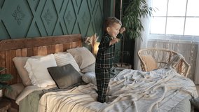 Cute little caucasian toddler boy in pajamas skipping and jumping up high on parents bed after waking up in cozy stylish bedroom. Happy child is having fun. Carefree childhood. Morning exercises - Powered by Shutterstock - Get 15% off with code: PIKWIZARD15