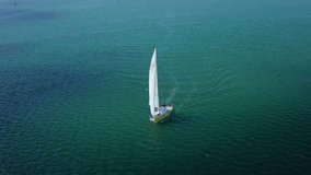Aerial Yacht sailing on open sea. Sailing boat panaramic video from drone. Sailing on sailboats at ocean bay. Cinematic serene, calm and relax concept