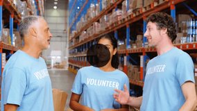 Animation of network of icons over diverse team of volunteers high fiving each other at warehouse. Global networking and logistics business technology concept - Powered by Shutterstock - Get 15% off with code: PIKWIZARD15