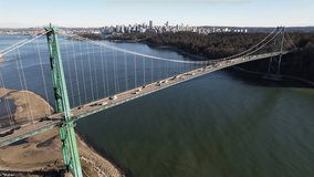 Footage of Lions Gate bridge with view of Downtown Vancouver and Stanley Park on a sunny spring day