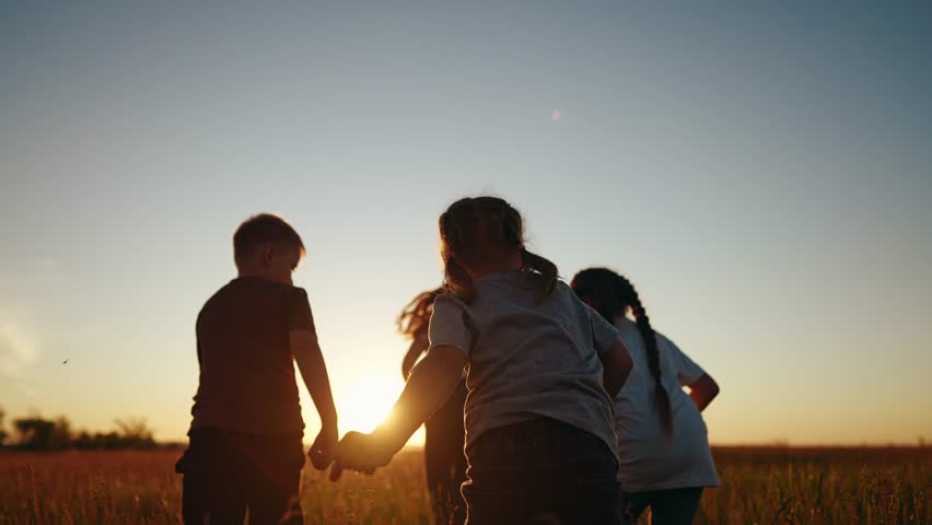 Children running in park at sunset. happy family kindergarten kids dream concept. Kids running in grass silhouette. Children playing outdoors silhouette. Kids playing in lifestyle park at sunrise Royalty-Free Stock Footage #1102576955