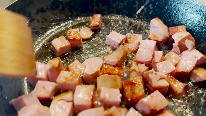 pieces of sausage fry in a pan close-up. delicious breakfast chef fries pieces of meat sausage. healthy eating concept. sizzling pork sausage slices in sunflower oil are fried in cholesterol pan