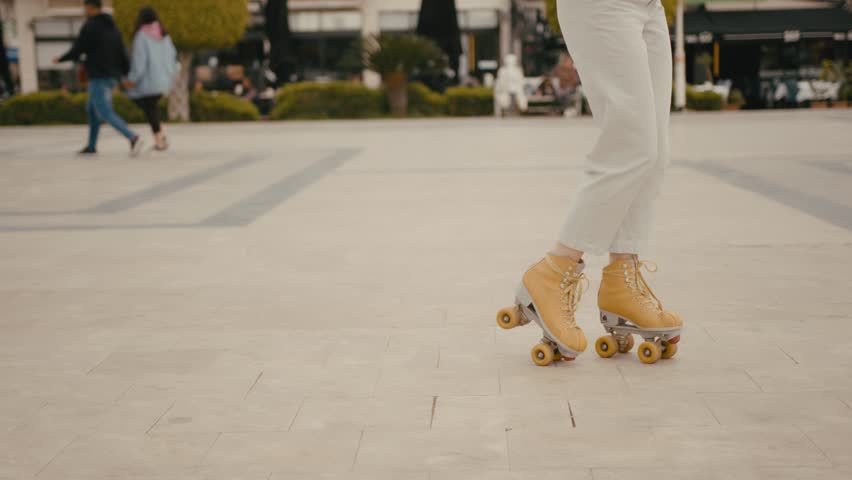 Young attractive woman dances on quads roller skates outdoors