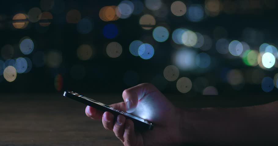 Male hand scrolling browsing on a smartphone at night time. Close-up of person using smartphone, browsing social network. Cinematic shot of male hand scroll through news feed on app on his smartphone. Royalty-Free Stock Footage #1102582111