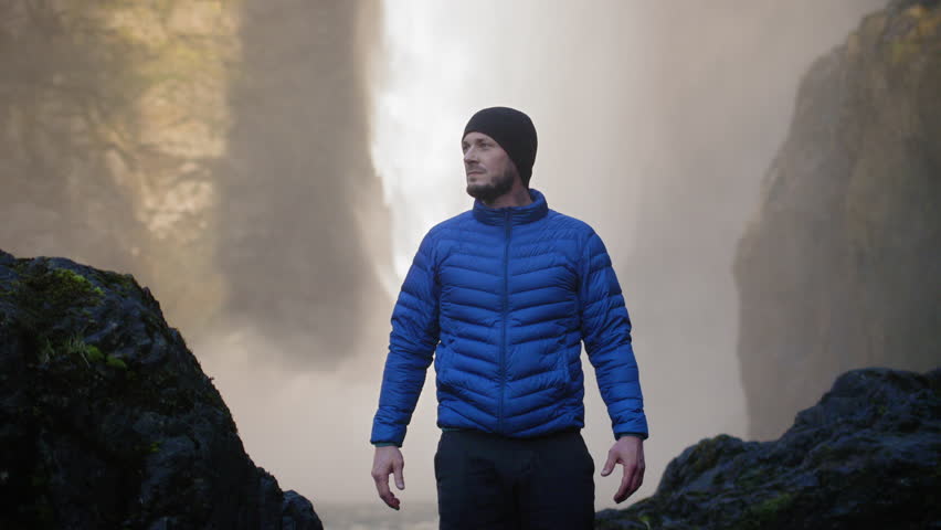 Adventurous Man Standing Under Amazing Waterfall
