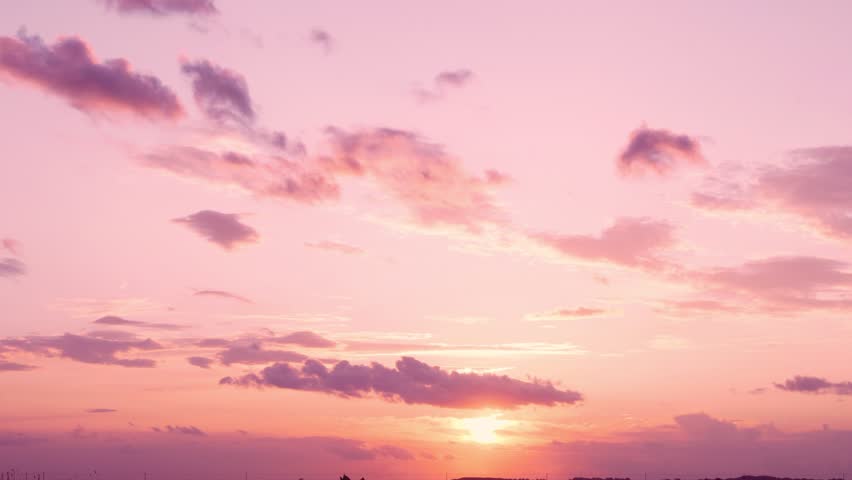 Amazing Pink Purple Orange Sunset of the Setting Sun over the Horizon and Feathery Light Colored Clouds. Time Lapse Of the Colorful Sunset Sky of the Sun and Clouds. Beautiful 4K Nature Background.