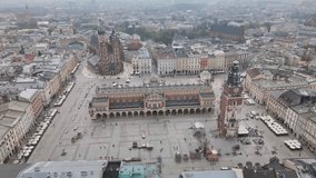Krakow Main Square aerial view video from drone. Cloth Hall - Sukiennice, City Hall Tower and St. Mary's - Mariacki - Church. 